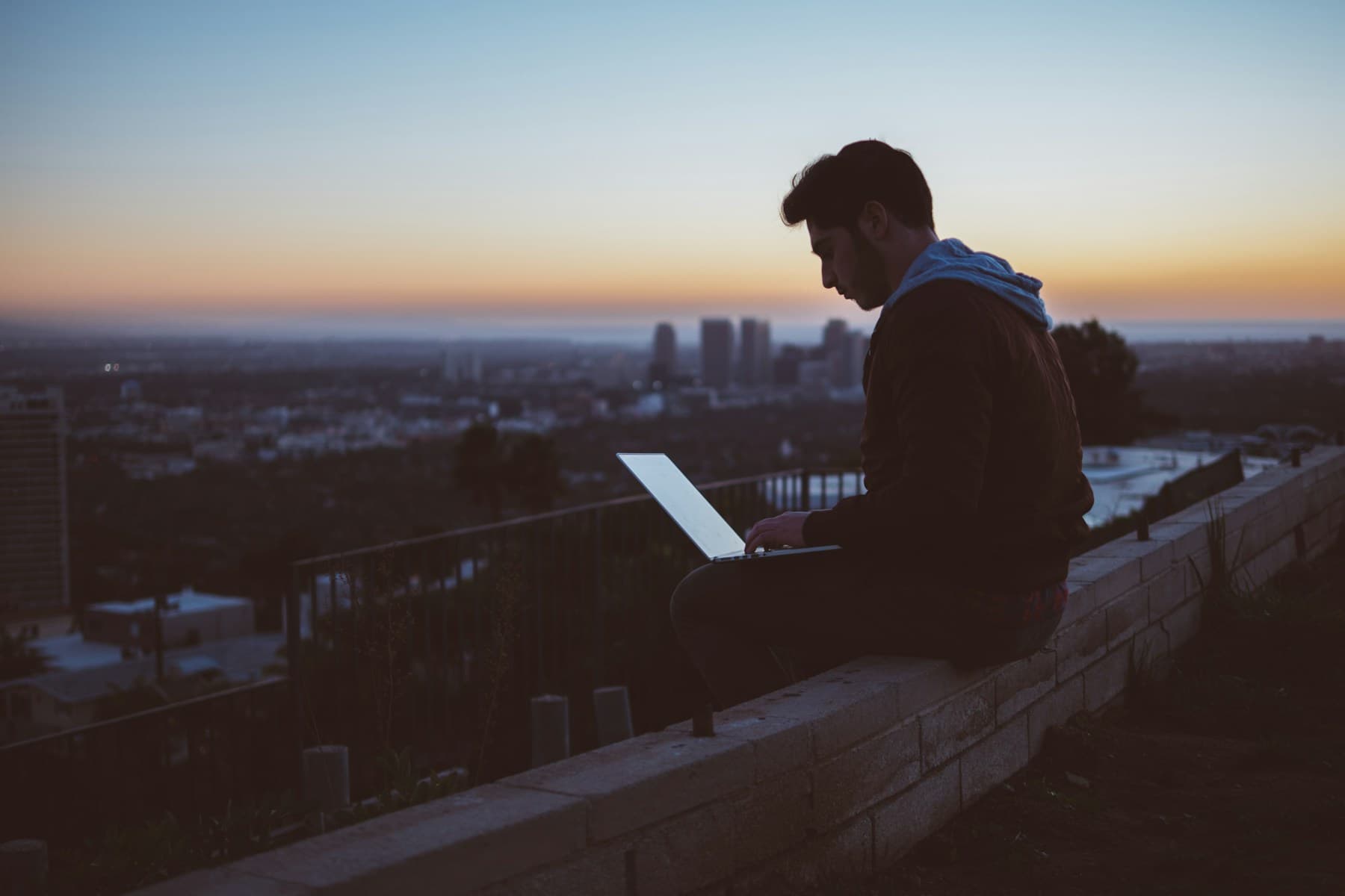 Researcher working on a laptop above a city